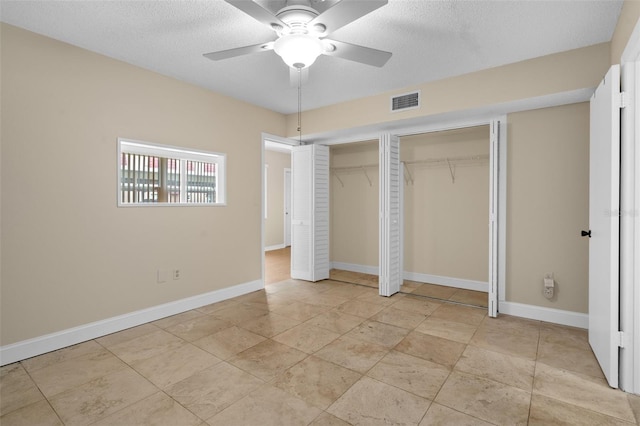 10033 64th Ave N Unit 4, Saint Petersburg, FL 33708 - unfurnished bedroom featuring multiple closets, a textured ceiling, and a ceiling fan