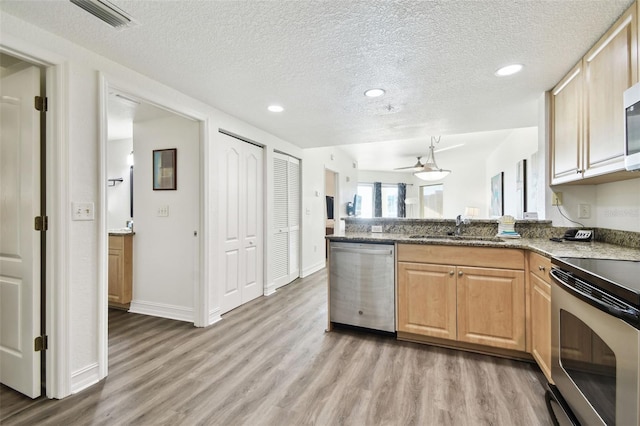 11605 Gulf Blvd Unit 402, Saint Petersburg, FL 33706 - kitchen featuring appliances with stainless steel finishes, light wood finished floors, a textured ceiling, a peninsula, and recessed lighting