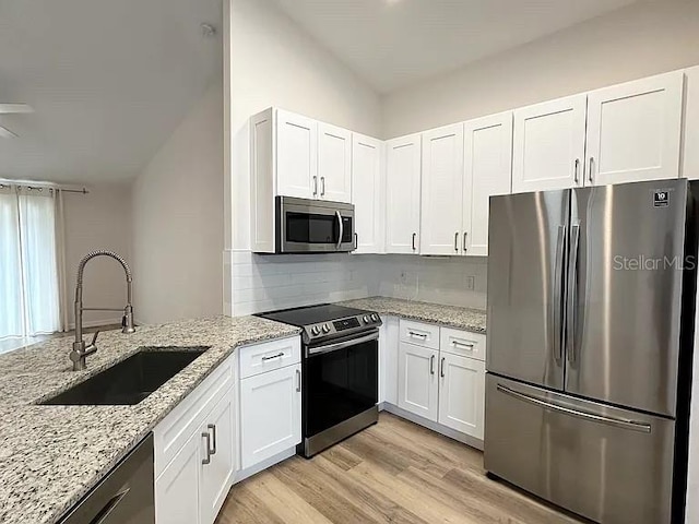 1737 N Lakewood Ave, Ocoee, FL 34761 - kitchen featuring stainless steel appliances, white cabinets, light wood-style floors, and backsplash