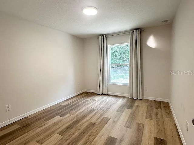 1737 N Lakewood Ave, Ocoee, FL 34761 - unfurnished room with wood finished floors and a textured ceiling