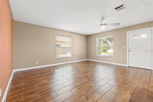 7112 2nd St N, Saint Petersburg, FL 33702 - empty room with wood tiled floors, a ceiling fan, and a textured ceiling