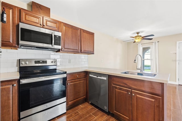 7112 2nd St N, Saint Petersburg, FL 33702 - kitchen featuring stainless steel appliances, dark wood finished floors, a peninsula, backsplash, and brown cabinets