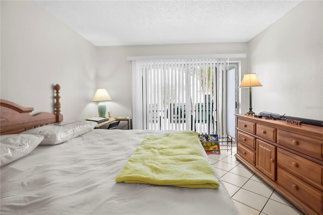 2625 State Road 590 Unit 723, Clearwater, FL 33759 - bedroom featuring access to exterior, light tile patterned floors, and a textured ceiling