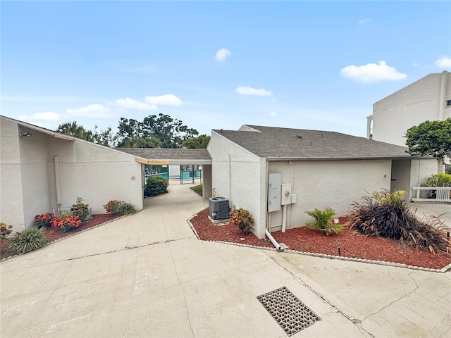 2625 State Road 590 Unit 723, Clearwater, FL 33759 - view of side of home with stucco siding, driveway, and a shingled roof