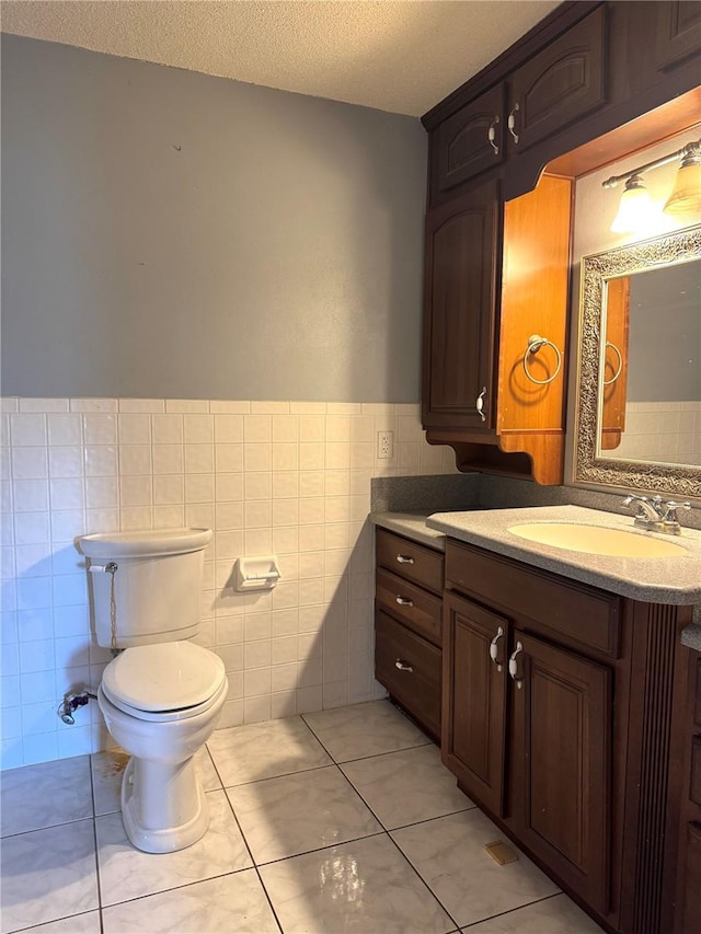 3645 E Country Side Dr, Inverness, FL 34452 - bathroom with tile walls, vanity, a textured ceiling, a wainscoted wall, and tile patterned floors