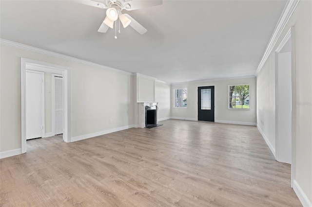 4313 W N A St, Tampa, FL 33609 - unfurnished living room with a fireplace with raised hearth, ornamental molding, a ceiling fan, and light wood-style flooring