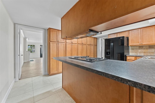 4313 W N A St, Tampa, FL 33609 - kitchen with black fridge with ice dispenser, electric cooktop, decorative backsplash, dark countertops, and a peninsula