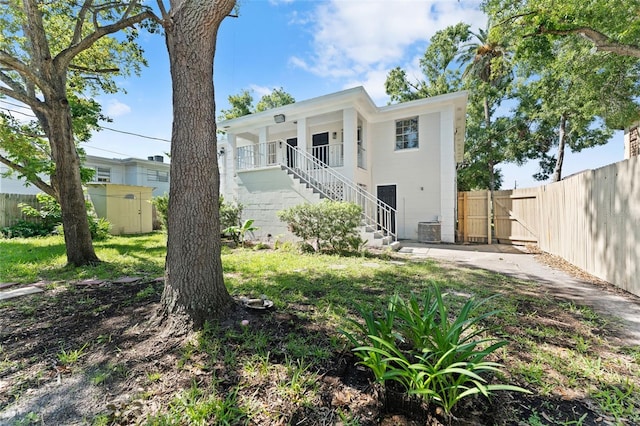 4313 W N A St, Tampa, FL 33609 - rear view of property featuring a gate, stairs, and a storage unit