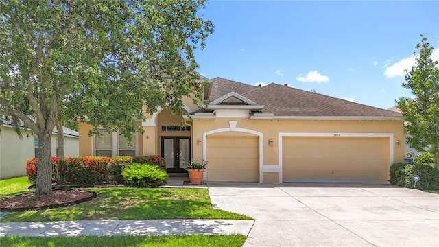 3409 61st Ter E, Ellenton, FL 34222 - view of front of home featuring french doors, a garage, driveway, stucco siding, and a front yard