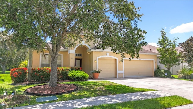 3409 61st Ter E, Ellenton, FL 34222 - obstructed view of property featuring stucco siding, a garage, driveway, and a front yard