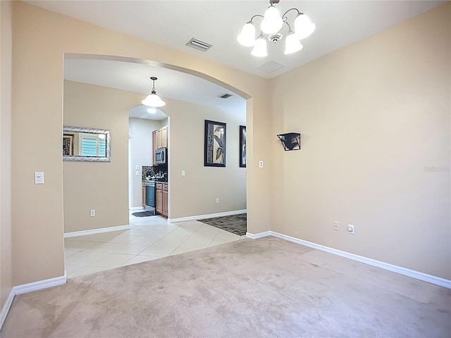 3409 61st Ter E, Ellenton, FL 34222 - spare room featuring light carpet, arched walkways, a chandelier, and light tile patterned flooring