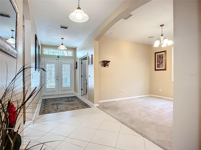 3409 61st Ter E, Ellenton, FL 34222 - entrance foyer featuring light colored carpet, arched walkways, light tile patterned flooring, and a chandelier
