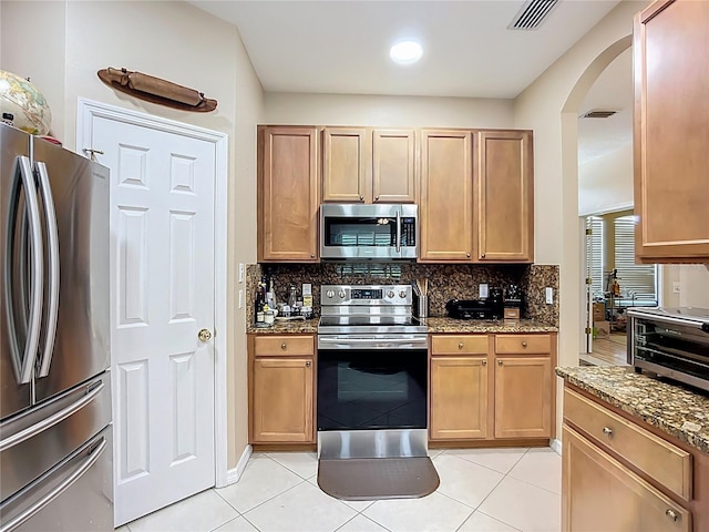 3409 61st Ter E, Ellenton, FL 34222 - kitchen with appliances with stainless steel finishes, arched walkways, decorative backsplash, and stone counters