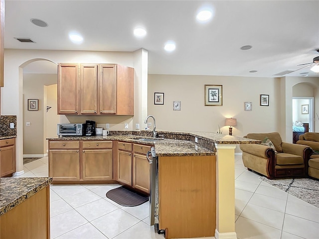 3409 61st Ter E, Ellenton, FL 34222 - kitchen featuring a peninsula, open floor plan, arched walkways, light tile patterned floors, and dark stone countertops