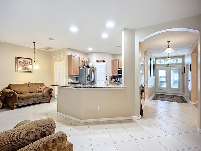 3409 61st Ter E, Ellenton, FL 34222 - kitchen featuring stainless steel appliances, arched walkways, light tile patterned flooring, open floor plan, and dark stone countertops