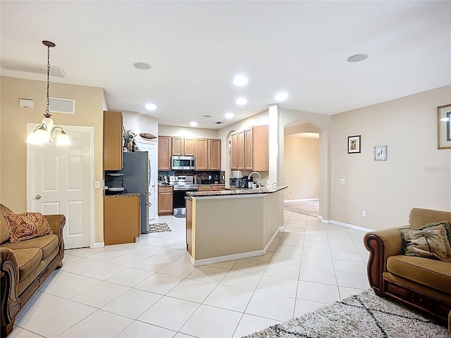 3409 61st Ter E, Ellenton, FL 34222 - kitchen with open floor plan, stainless steel appliances, arched walkways, decorative backsplash, and light tile patterned flooring