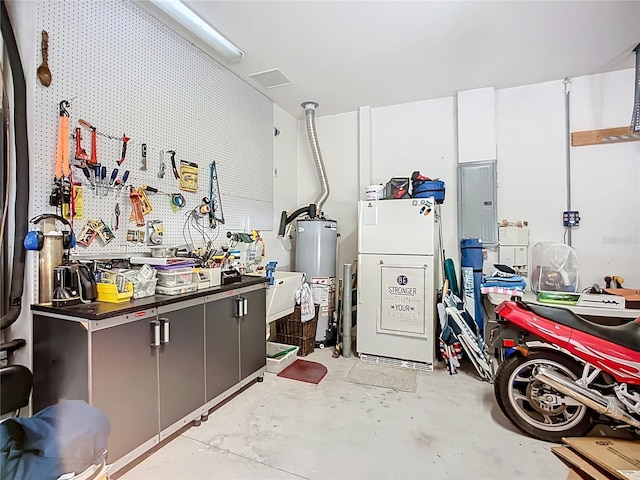 3409 61st Ter E, Ellenton, FL 34222 - garage featuring a workshop area, gas water heater, refrigerator, and electric panel