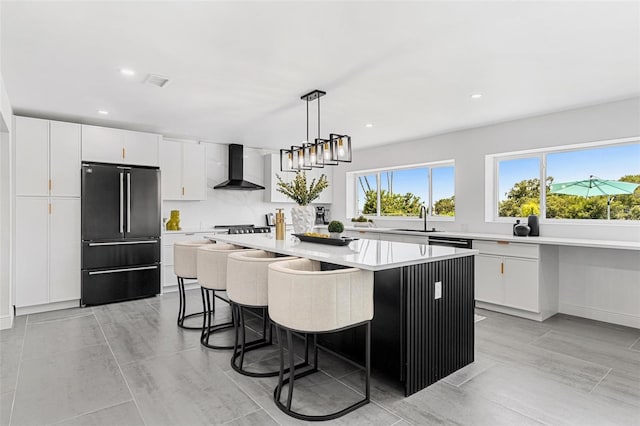 380 Colony Point Rd S, Saint Petersburg, FL 33705 - kitchen with high end refrigerator, wall chimney range hood, plenty of natural light, light countertops, and recessed lighting