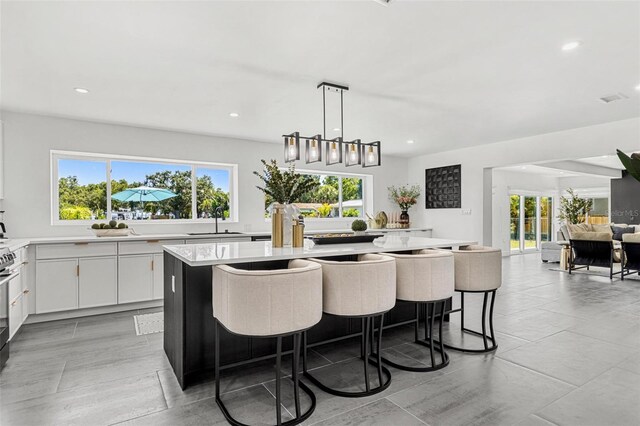 380 Colony Point Rd S, Saint Petersburg, FL 33705 - kitchen with light countertops, a kitchen island, recessed lighting, healthy amount of natural light, and white cabinets