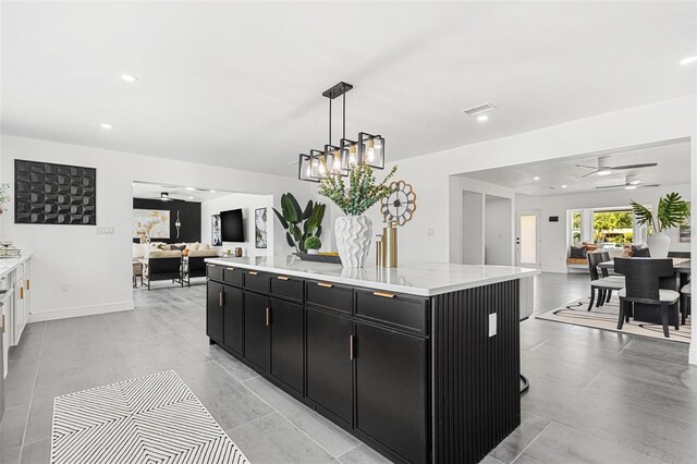 380 Colony Point Rd S, Saint Petersburg, FL 33705 - kitchen featuring dark cabinetry, open floor plan, a center island, a ceiling fan, and hanging light fixtures