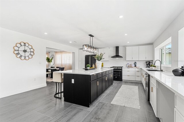 380 Colony Point Rd S, Saint Petersburg, FL 33705 - kitchen featuring wall chimney exhaust hood, black appliances, healthy amount of natural light, light countertops, and recessed lighting