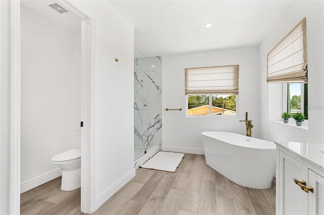 380 Colony Point Rd S, Saint Petersburg, FL 33705 - bathroom with a marble finish shower, a soaking tub, wood finished floors, vanity, and recessed lighting