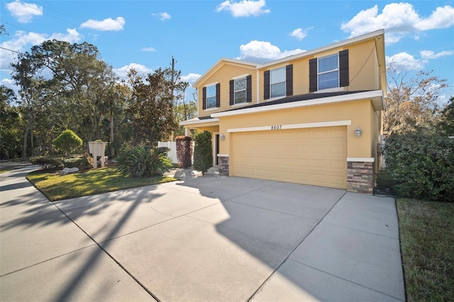 8607 Tidal Breeze Dr, Riverview, FL 33569 - view of front of home with stucco siding, a garage, stone siding, and driveway