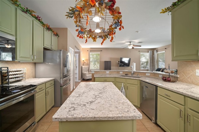 8607 Tidal Breeze Dr, Riverview, FL 33569 - kitchen featuring stainless steel appliances, a center island, a ceiling fan, a peninsula, and backsplash