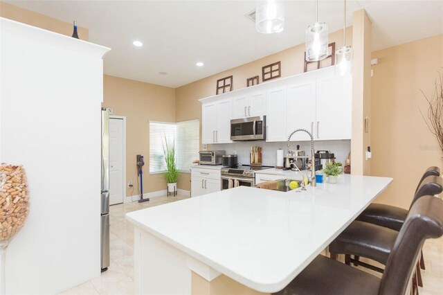 11913 Butler Woods Cir, Riverview, FL 33579 - kitchen featuring appliances with stainless steel finishes, a kitchen breakfast bar, a peninsula, light countertops, and recessed lighting