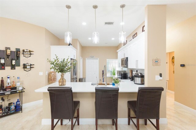 11913 Butler Woods Cir, Riverview, FL 33579 - kitchen featuring a peninsula, white cabinets, a breakfast bar, and recessed lighting