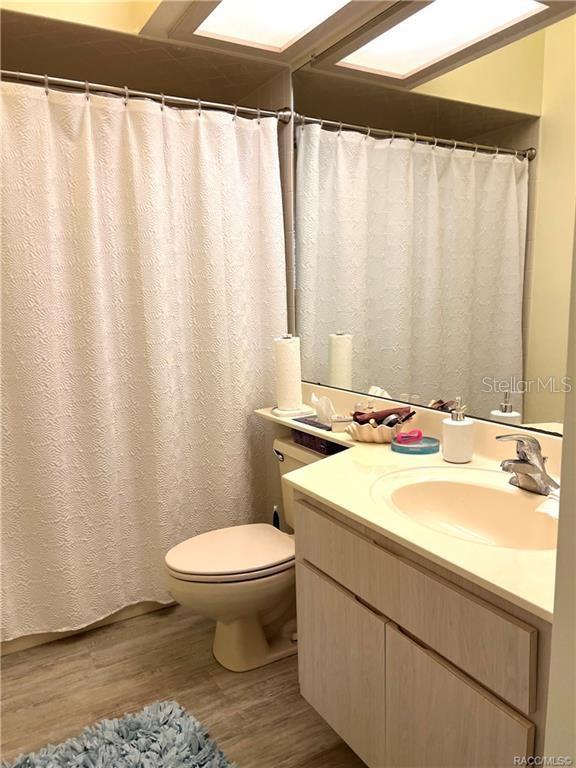 6847 E Queensbury Ln, Inverness, FL 34452 - full bathroom featuring wood finished floors and vanity