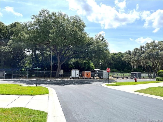 6847 E Queensbury Ln, Inverness, FL 34452 - view of asphalt street featuring traffic signs, view of scattered trees, and curbs