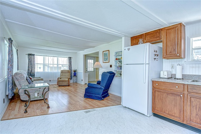 35014 Carl Ave, Zephyrhills, FL 33541 - kitchen featuring freestanding refrigerator, open floor plan, brown cabinetry, plenty of natural light, and beamed ceiling