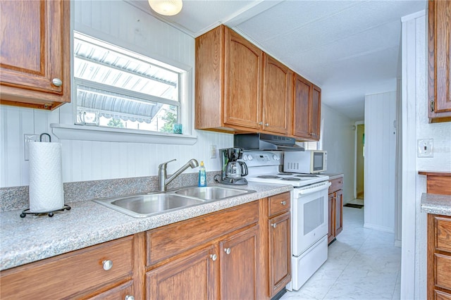 35014 Carl Ave, Zephyrhills, FL 33541 - kitchen with white appliances, under cabinet range hood, light countertops, and brown cabinets