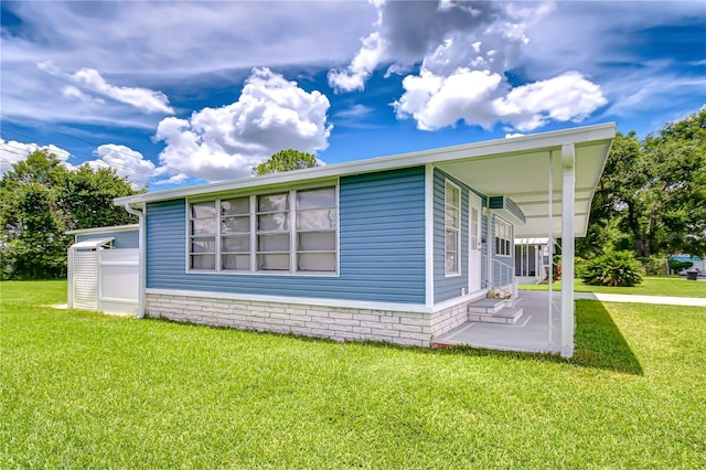 35014 Carl Ave, Zephyrhills, FL 33541 - view of property exterior with a lawn and a patio