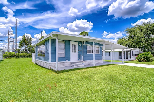 35014 Carl Ave, Zephyrhills, FL 33541 - manufactured / mobile home with a front lawn, driveway, an attached carport, entry steps, and a chimney