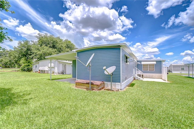 35014 Carl Ave, Zephyrhills, FL 33541 - back of house featuring entry steps, a carport, and a lawn