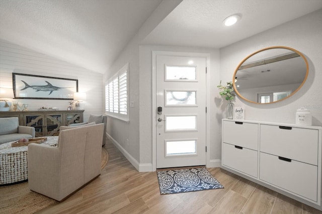 11763 Saree Ct, Largo, FL 33778 - foyer with lofted ceiling, light wood finished floors, and a textured ceiling