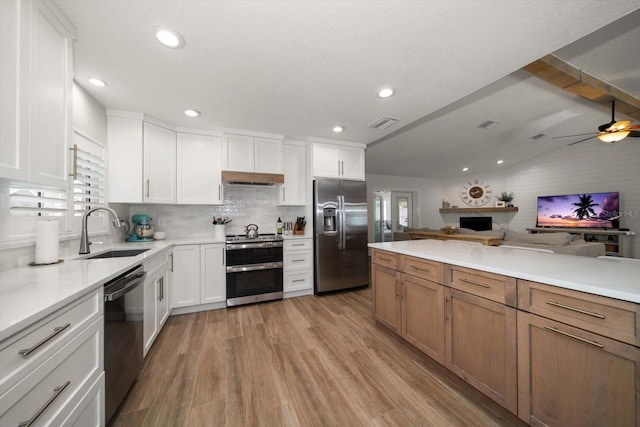 11763 Saree Ct, Largo, FL 33778 - kitchen with appliances with stainless steel finishes, open floor plan, light wood-type flooring, light countertops, and tasteful backsplash