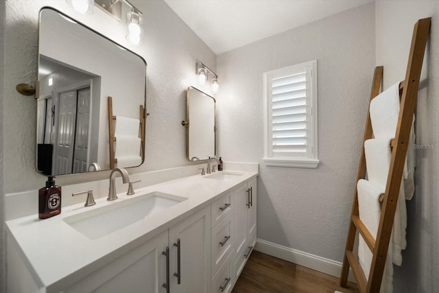 11763 Saree Ct, Largo, FL 33778 - bathroom with double vanity, wood finished floors, and a textured wall