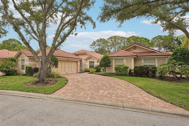 3854 Lyndhurst Ct, Sarasota, FL 34235 - mediterranean / spanish-style house featuring stucco siding, decorative driveway, a garage, a tile roof, and a front lawn