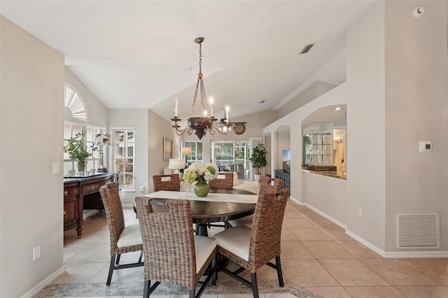 3854 Lyndhurst Ct, Sarasota, FL 34235 - dining space with a chandelier, lofted ceiling, light tile patterned flooring, and arched walkways