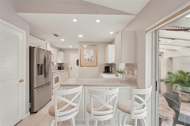 3854 Lyndhurst Ct, Sarasota, FL 34235 - kitchen with white appliances, backsplash, light countertops, a peninsula, and white cabinetry