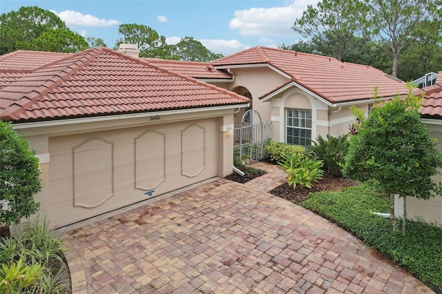 3854 Lyndhurst Ct, Sarasota, FL 34235 - mediterranean / spanish-style home with stucco siding, a tile roof, a chimney, and a garage