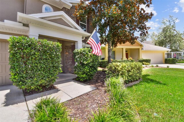 3530 Brook Crossing Dr, Brandon, FL 33511 - view of front facade featuring stucco siding, concrete driveway, a front yard, and stone siding