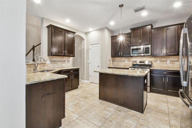 3530 Brook Crossing Dr, Brandon, FL 33511 - kitchen featuring appliances with stainless steel finishes, tasteful backsplash, arched walkways, light stone countertops, and recessed lighting