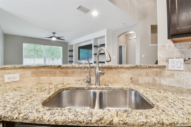 3530 Brook Crossing Dr, Brandon, FL 33511 - kitchen with a ceiling fan, decorative backsplash, and light stone countertops
