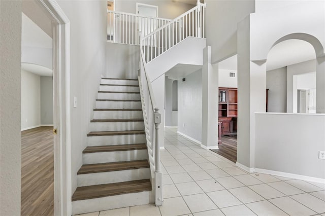 25737 Frith St, Land O Lakes, FL 34639 - stairs featuring arched walkways, a towering ceiling, and tile patterned floors