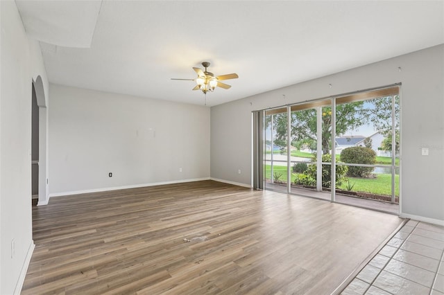 25737 Frith St, Land O Lakes, FL 34639 - empty room with ceiling fan, wood finished floors, a water view, and arched walkways