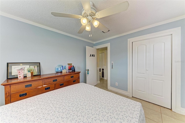 1908 N Brink Ave, Sarasota, FL 34234 - bedroom with light tile patterned floors, a textured ceiling, ornamental molding, a closet, and a ceiling fan
